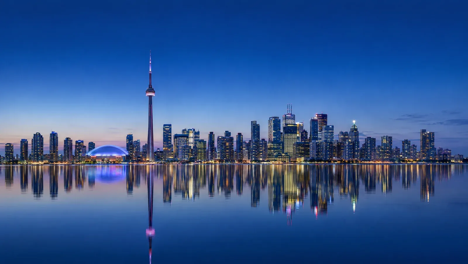 The Toronto skyline at dusk, seen across the harbor — Upstream Works is headquartered in the Greater Toronto Area