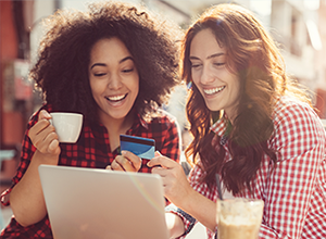 Two customers seeing laptop and holding a card